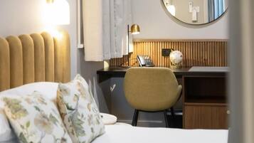 Habitación de hotel con una cama, un escritorio, una silla, un globo terráqueo y un teléfono.