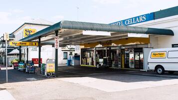 A gas station with a 'Sip n Save' convenience store, a 'Hotel Cellars' building, and a 'No Entry' sign.