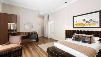 A bedroom with a large bed, a desk, a chair, and a wardrobe.