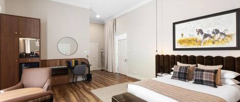 Un dormitorio con una cama grande, un escritorio, una silla y un armario.
