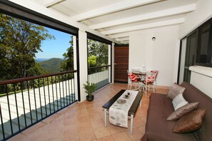 A balcony with a table, chairs, and a sofa. - Mapleton Falls Accommodation (Mapleton)