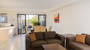 Un salon moderne comprenant un ensemble de canapés, une table basse et un coin repas avec une table et des chaises.