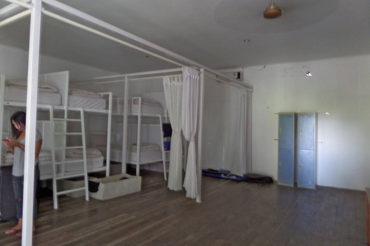 Huone, jossa on kerrossängyt, kattotuuletin ja ovi.