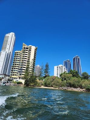 Un paysage urbain côtier avec de hauts immeubles, une plage et un ciel bleu dégagé.