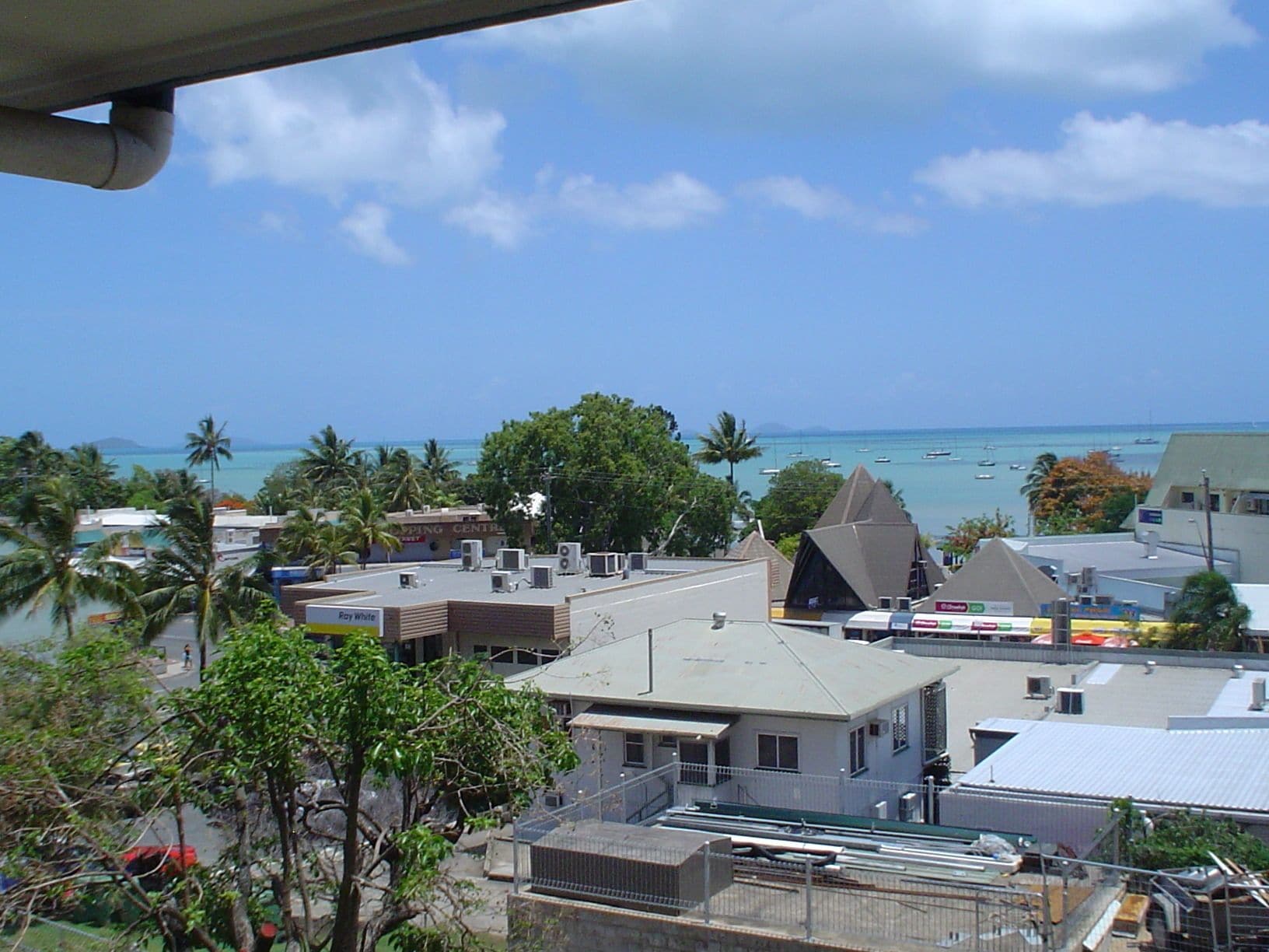 A coastal view with buildings, a clear sky, and the sea.