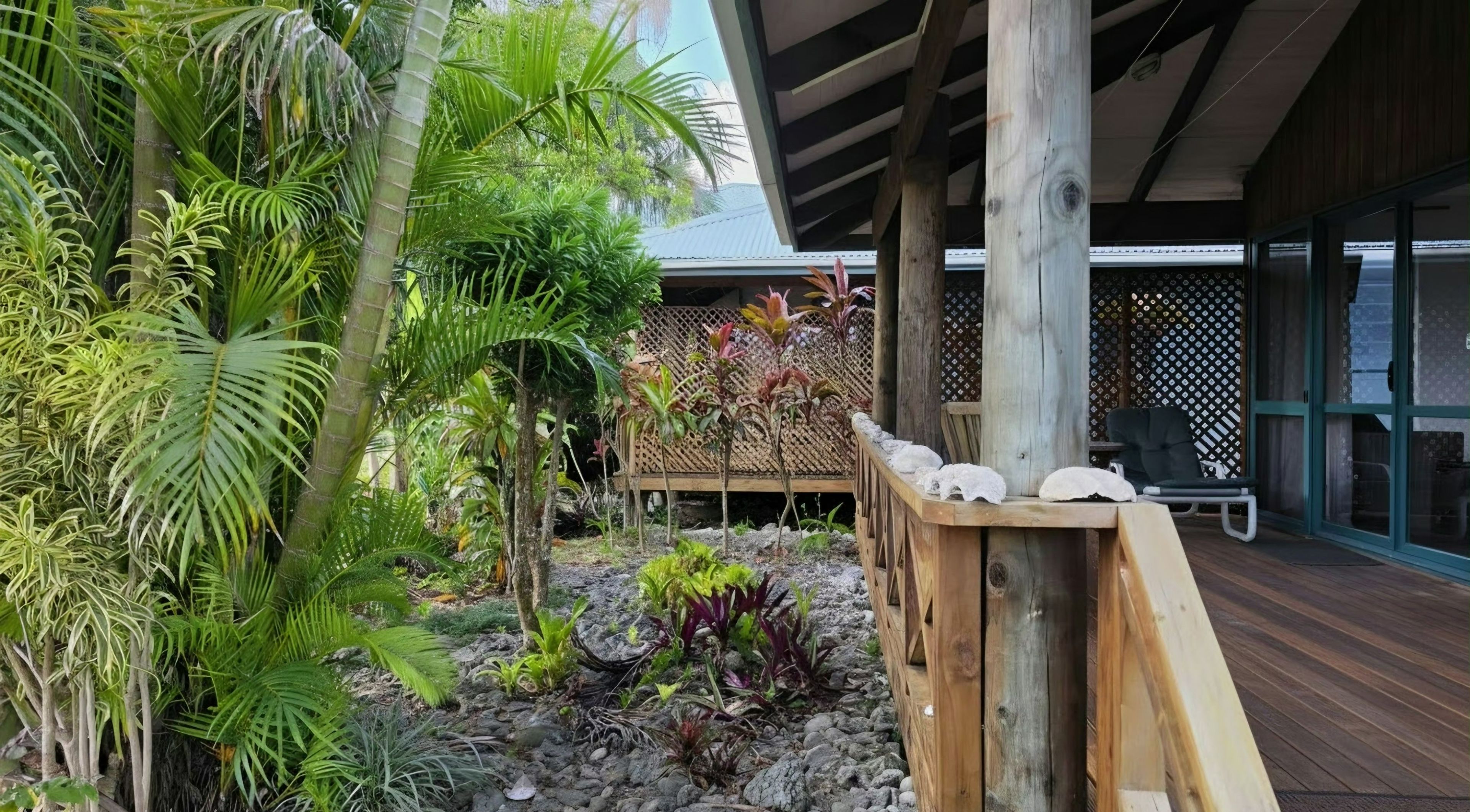 A wooden deck with a seating area and a covered section with a patterned wall.