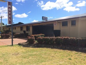 A motel with a clear entrance, a signboard, and a parking area. - James Street Motor Inn (South Toowoomba)