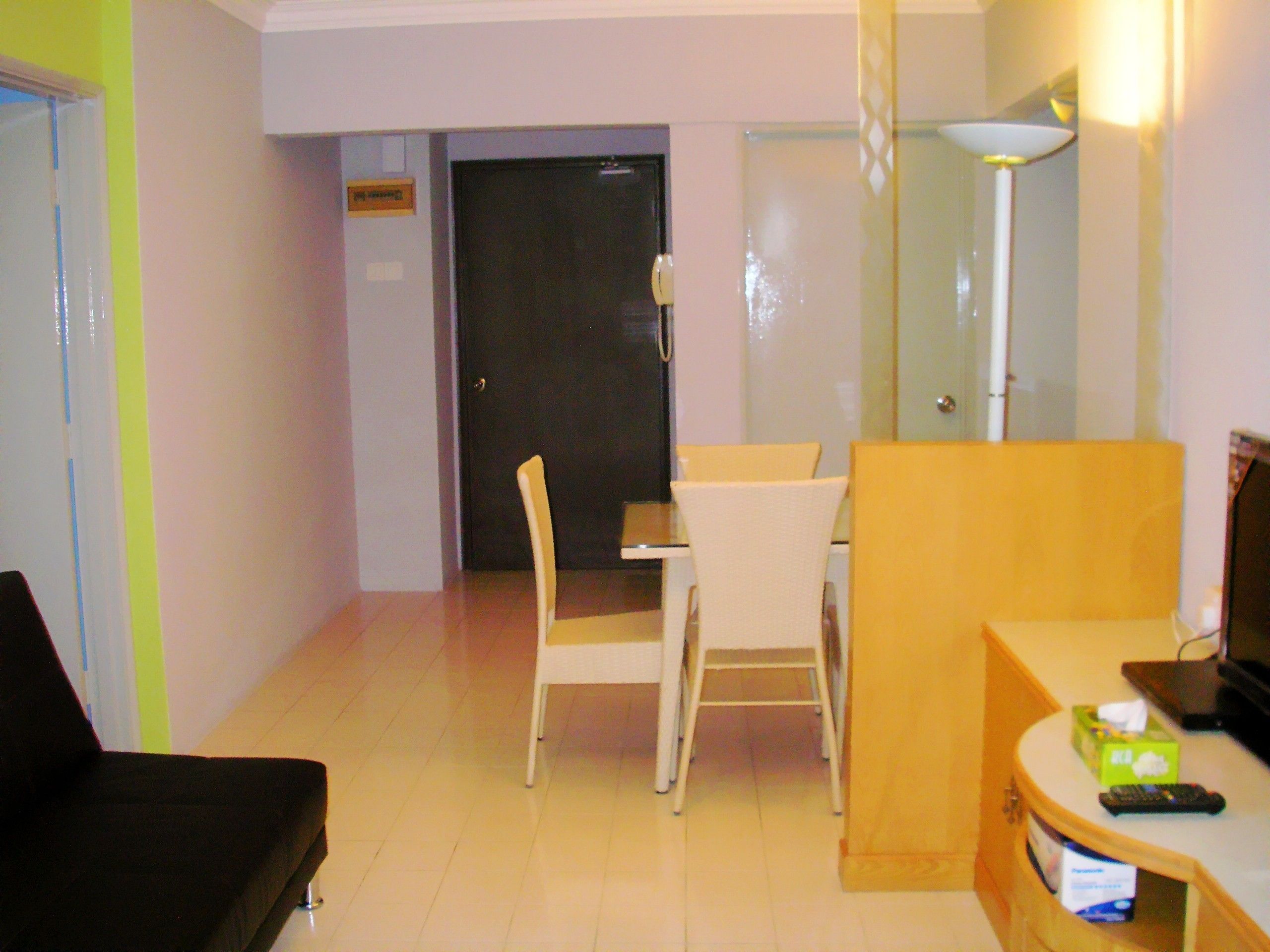 A hotel room with a bed, a desk, a chair, a lamp, and a television.