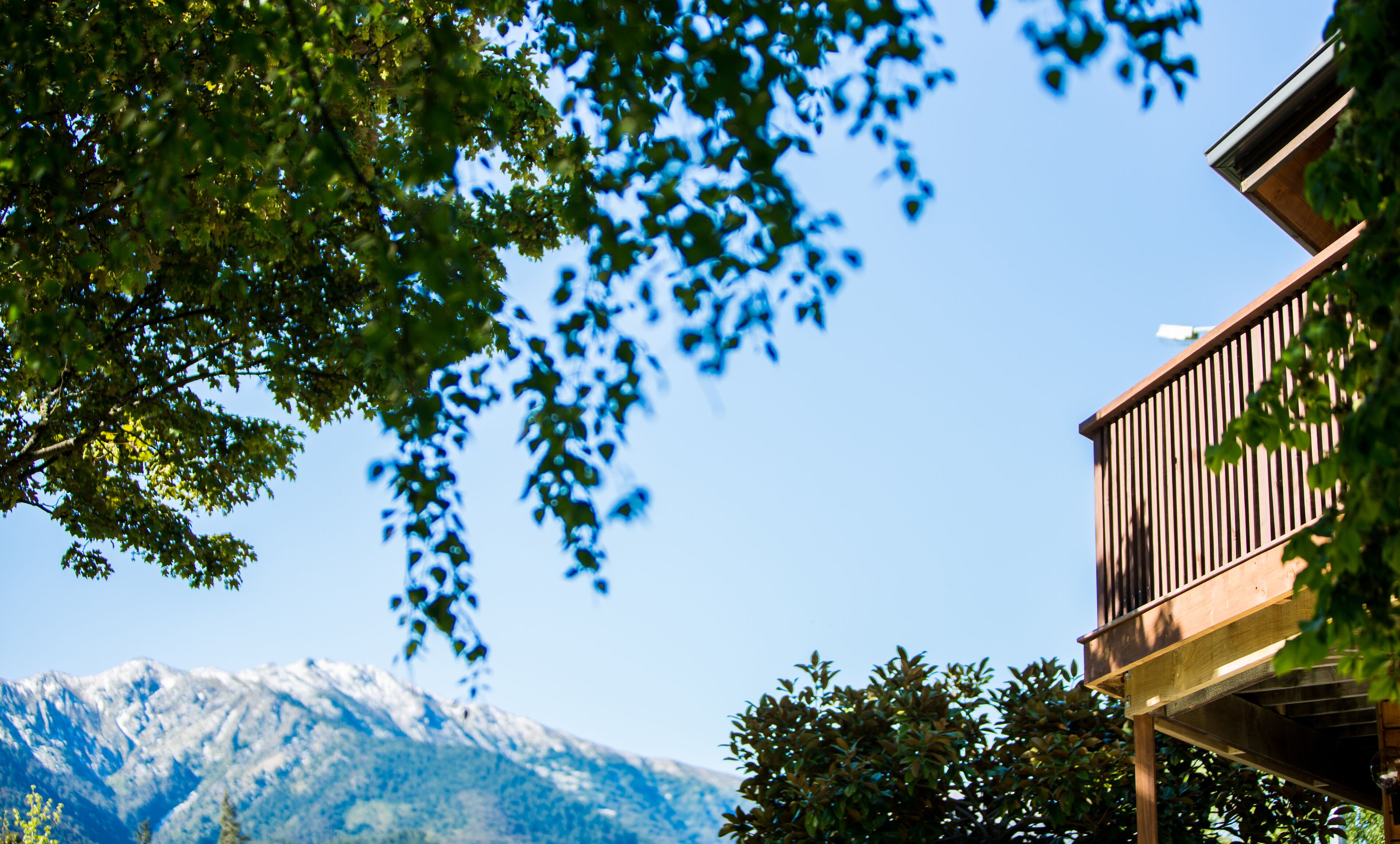 A wooden balcony with a mountain view.