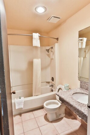 A bathroom with a bathtub, toilet, and sink.