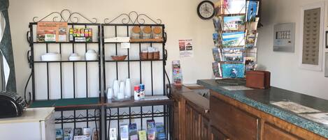 A reception area with a wooden counter, a clock, and various informational posters and brochures on the walls.