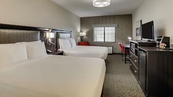 Habitación de hotel con dos camas, un escritorio, un televisor y un minibar.