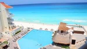 A resort with a large swimming pool, beach, and ocean view. - Amigo Rental (Cancun)