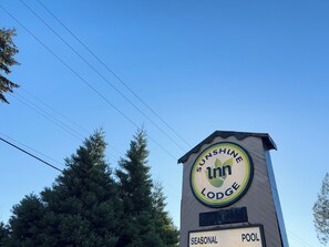 A sign for Sunshine Inn Lodge with a seasonal pool. - Sunshine Lodge (Gibsons)
