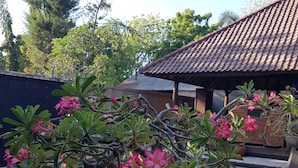 A potted plant with pink flowers by a swimming pool. - Gili Exotic Villas (Gili Trawangan)