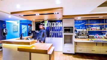 Check-in and unwind in our welcoming lobby, featuring a reception desk, digital display, and convenient amenities.