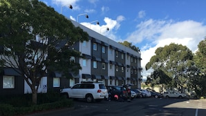 A multi-story building with a parking lot.