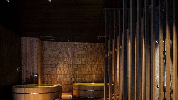 A traditional Japanese onsen with wooden walls and two hot tubs. - Hotel Shikanoyu (Sapporo)