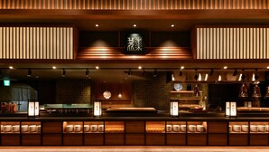 A modern restaurant interior with a wooden ceiling, recessed lighting, and a sushi bar. - Hotel Shikanoyu (Sapporo)