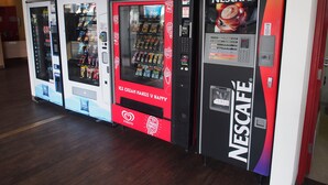 Automatische verkoopapparaten met diverse drankjes, waaronder een Nescafé automaat.