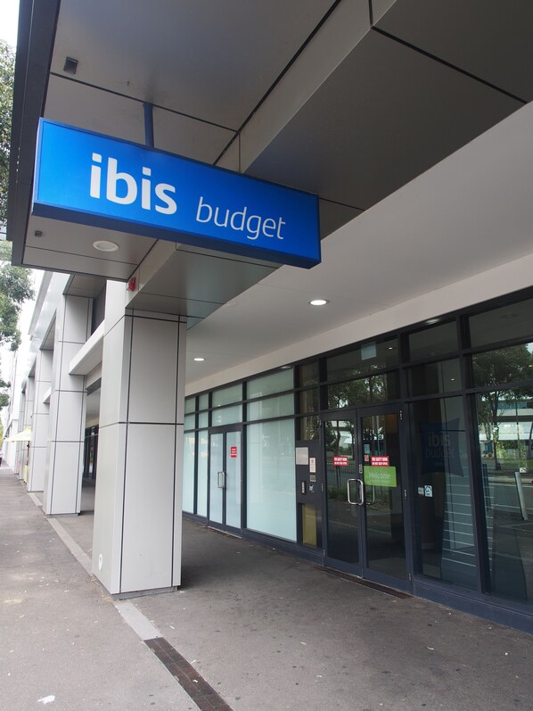 Um edifício moderno com uma placa azul que diz 'ibis budget'.