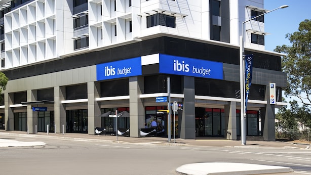 A modern building with a blue sign reading "ibis budget."