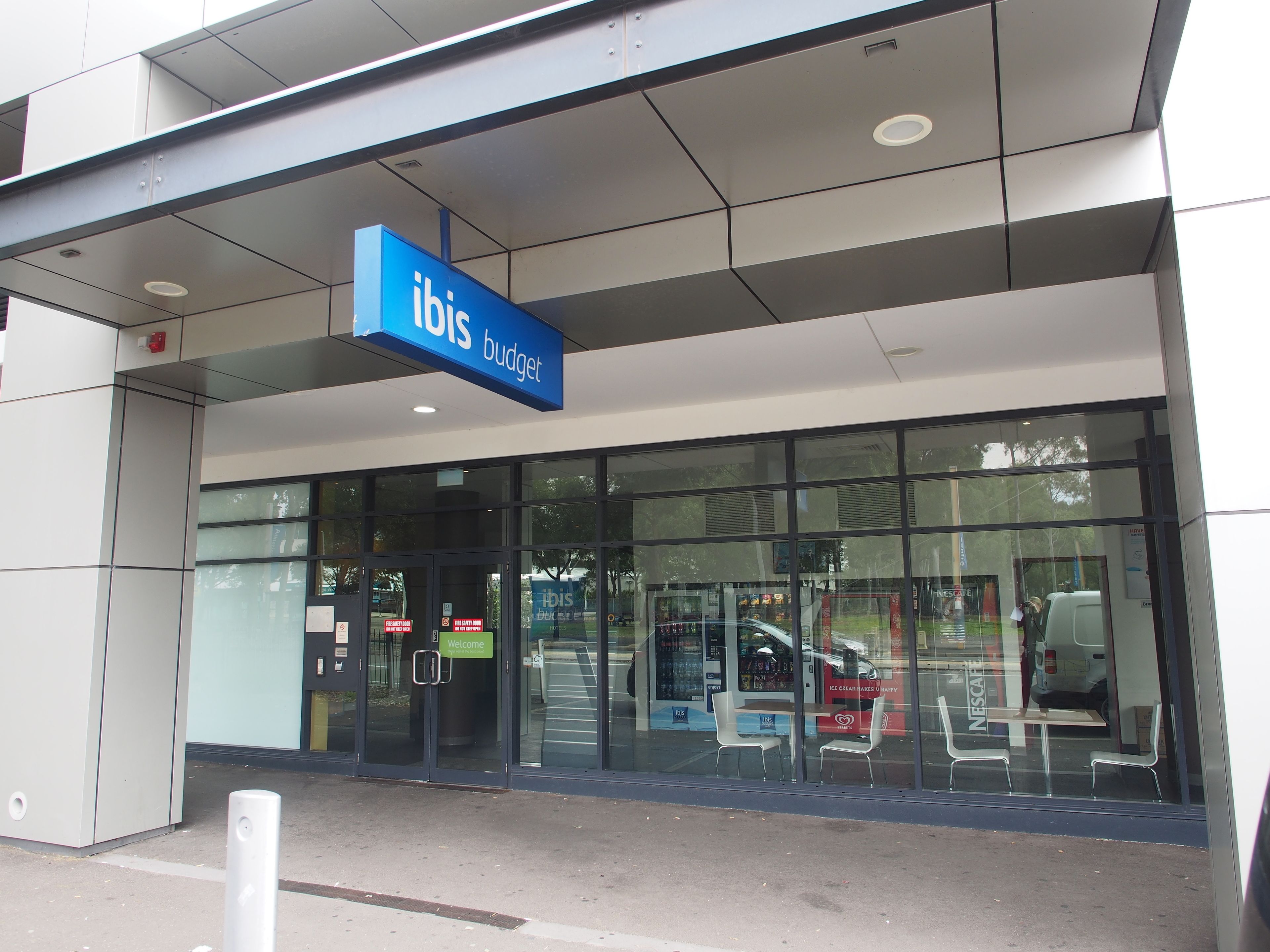 A modern building with a blue sign reading "ibis budget."