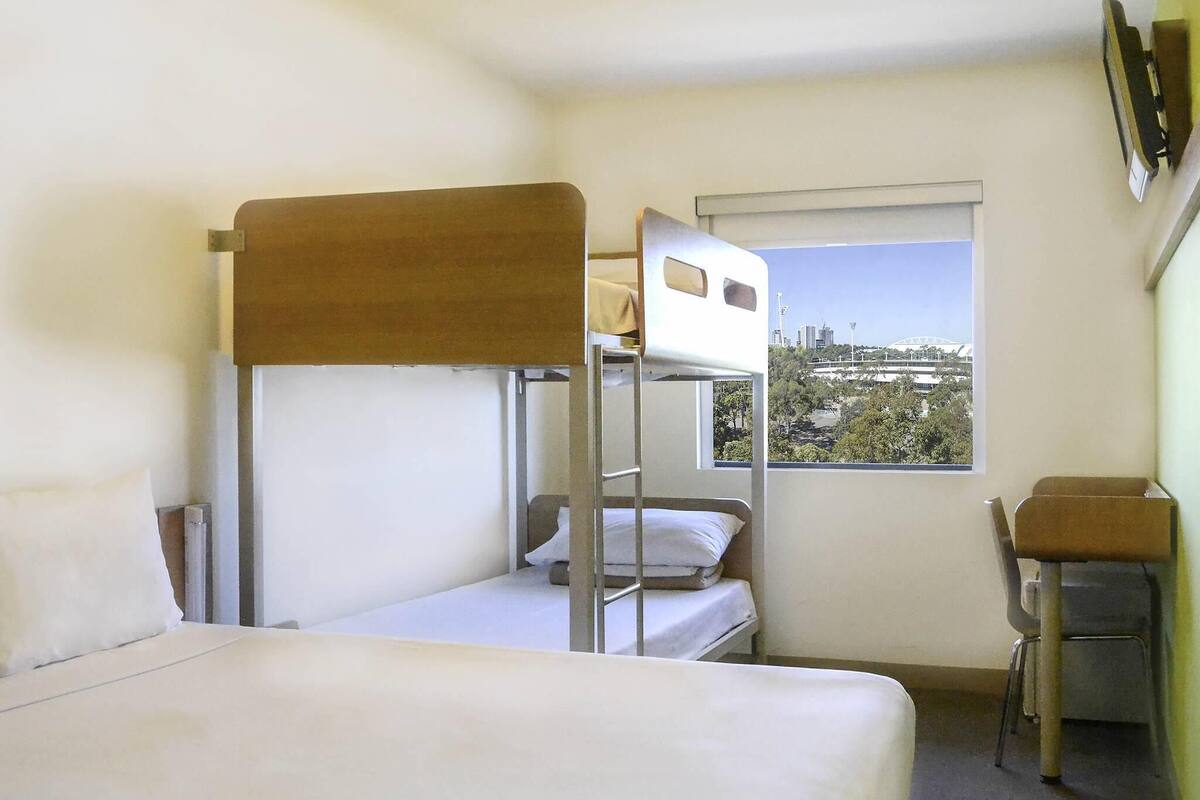 Habitación con literas y vista a la ciudad desde la ventana.