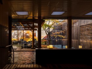 A traditional wooden interior with a view of an outdoor garden. - Hanamomiji (Sapporo)