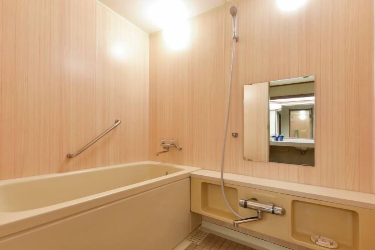 Pengering rambut, sandal, toilet dengan bidet elektronik, dan handuk