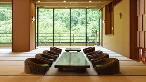 Una habitación tradicional japonesa con suelo de tatami, una mesa baja y sillas tejidas.