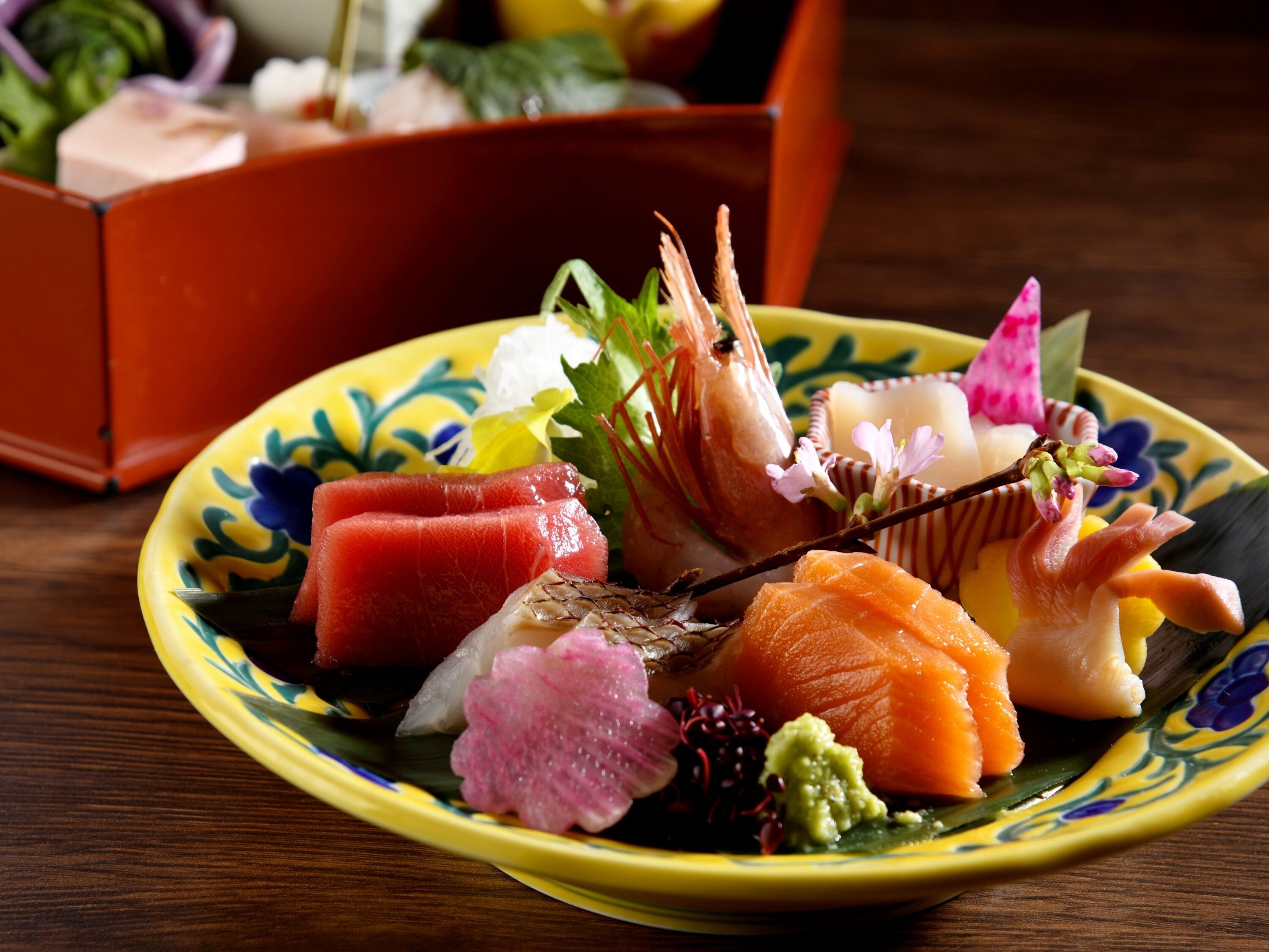 A plate of sushi with various toppings and a decorative flower.