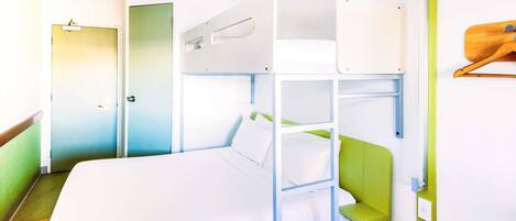 A bunk bed with a green headboard and white bedding in a room with a wooden floor and a green wall.