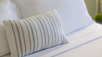 Un canapé blanc avec un coussin à rayures.