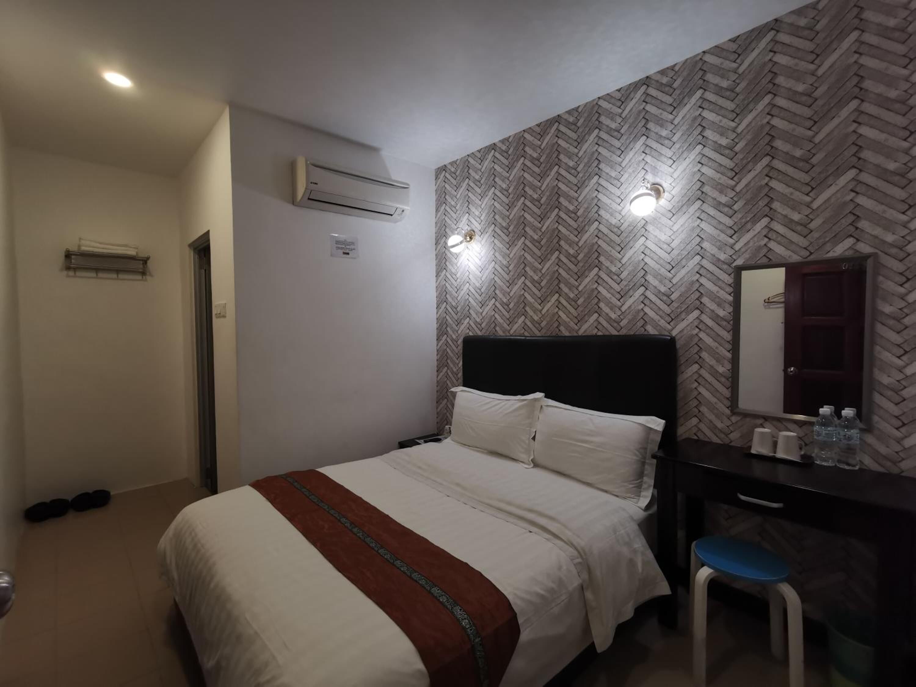 Une chambre d’hôtel équipée d’un lit, d’une commode, d’un miroir et d’un appareil de climatisation.
