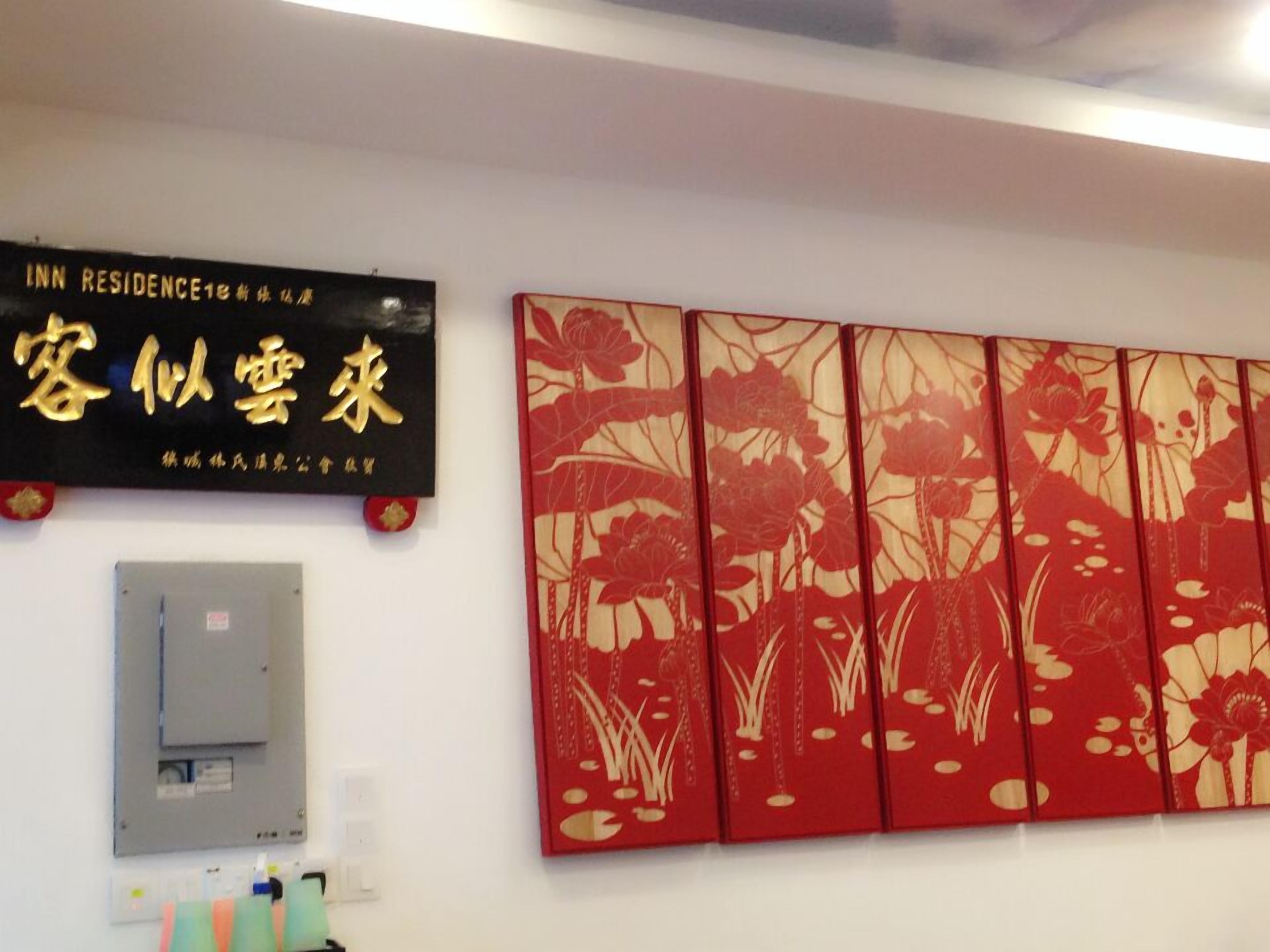 A wall with a sign for 'INN RESIDENCE' and a decorative red and gold floral panel.