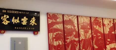 A wall with a sign for 'INN RESIDENCE' and a decorative red and gold floral panel.