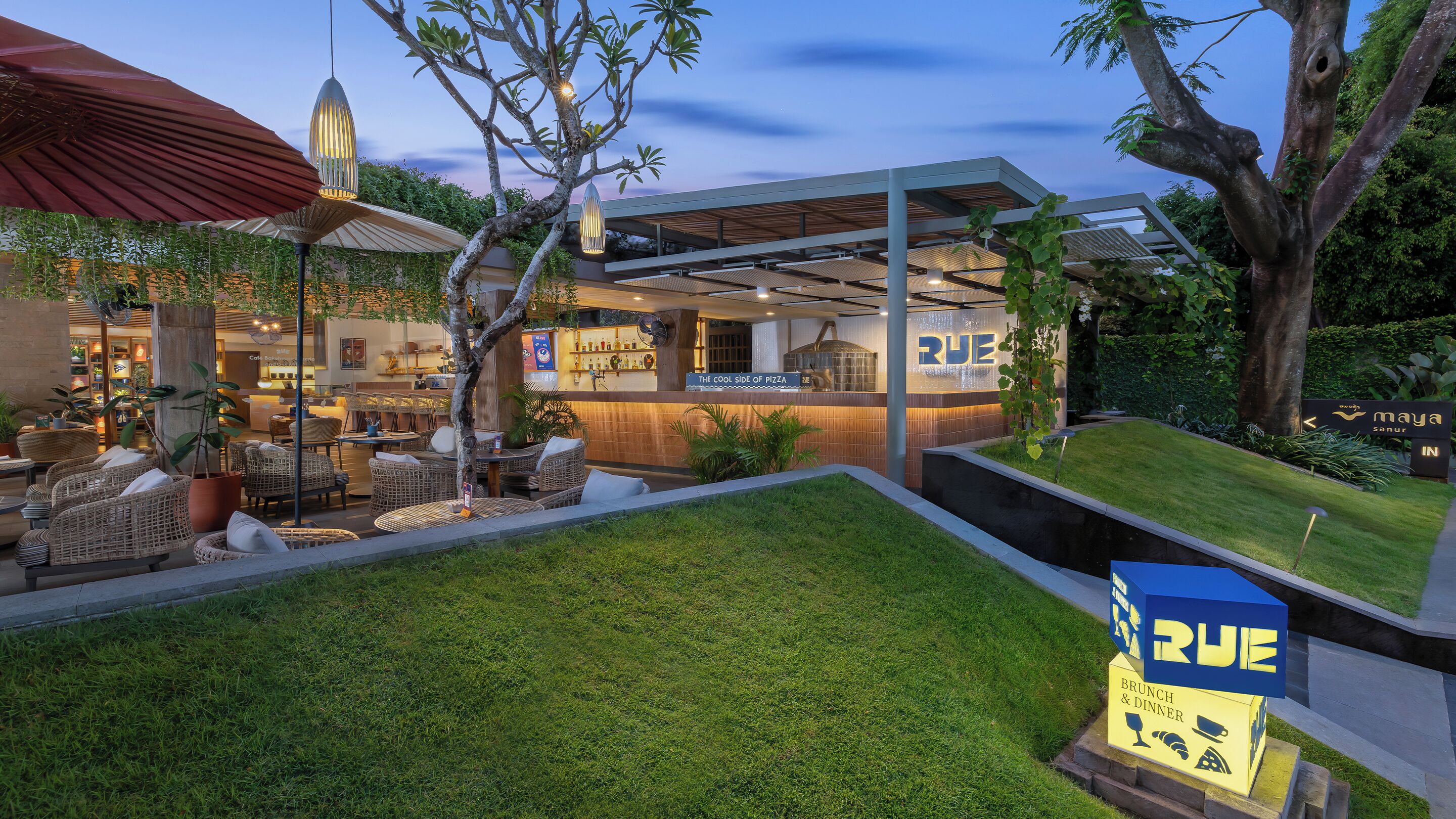 Un restaurante con terraza, diseño arquitectónico moderno y un letrero que indica que es la parte más fresca de la pizza.
