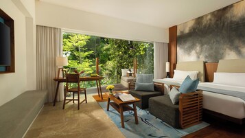 Une chambre d’hôtel moderne avec une grande fenêtre, un canapé, un lit, un bureau et une chaise.