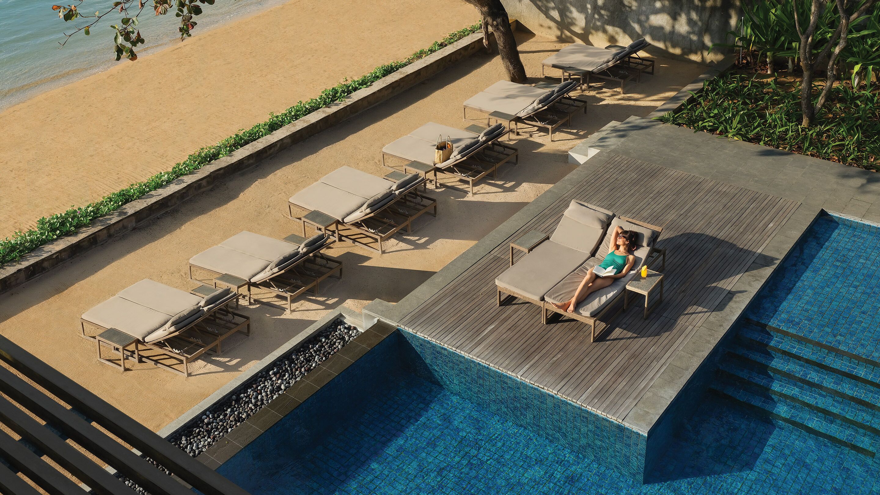 A poolside area with lounge chairs and a pool.
