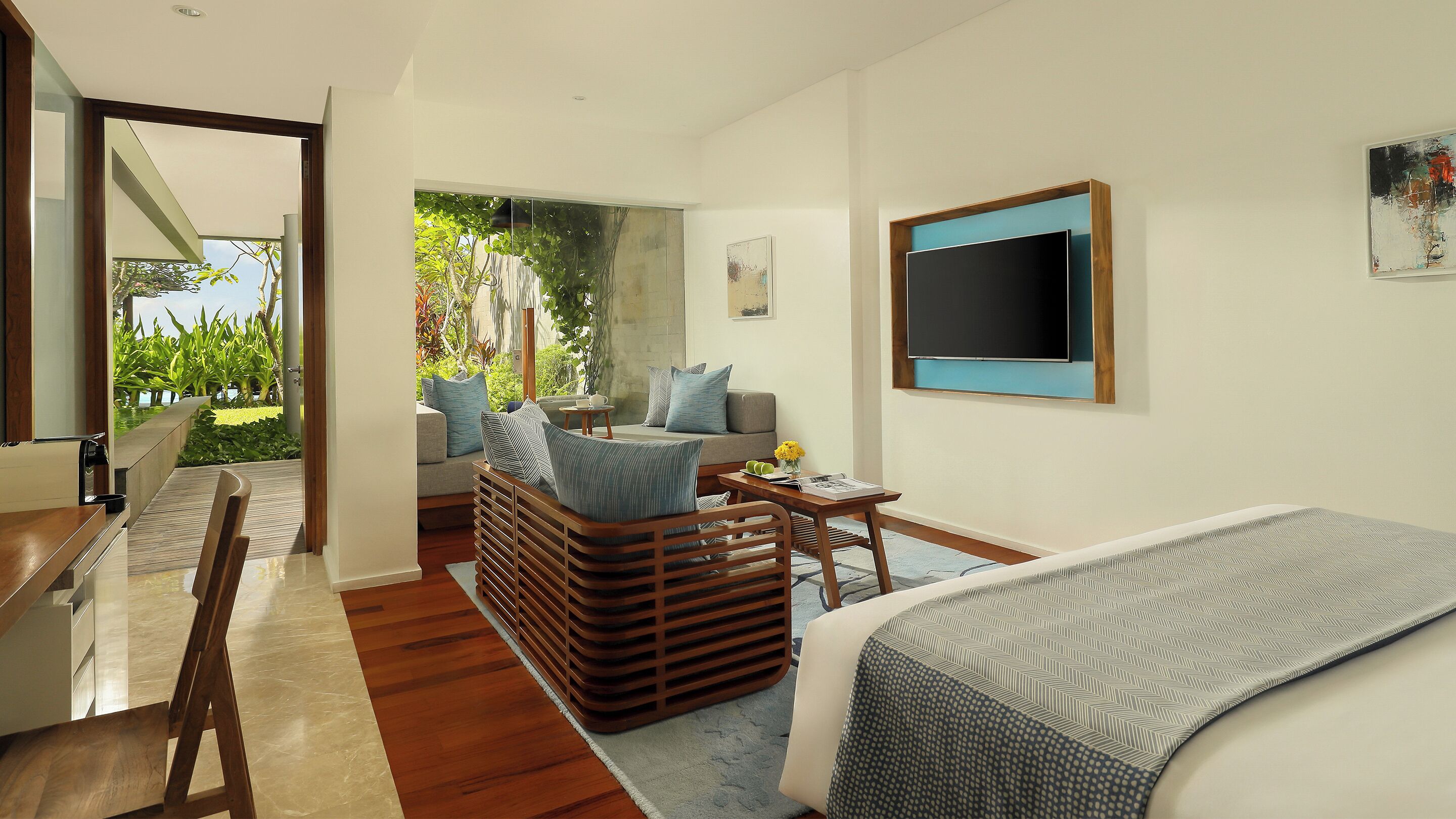 Une chambre d’hôtel moderne équipée d’un lit, d’un bureau, d’un canapé et d’une télévision.