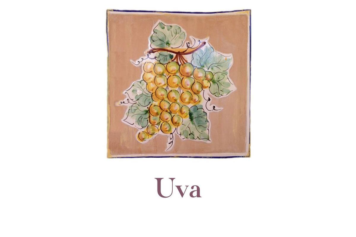 Une serviette ornée d’une illustration de vigne et portant le mot « Uva » en dessous.
