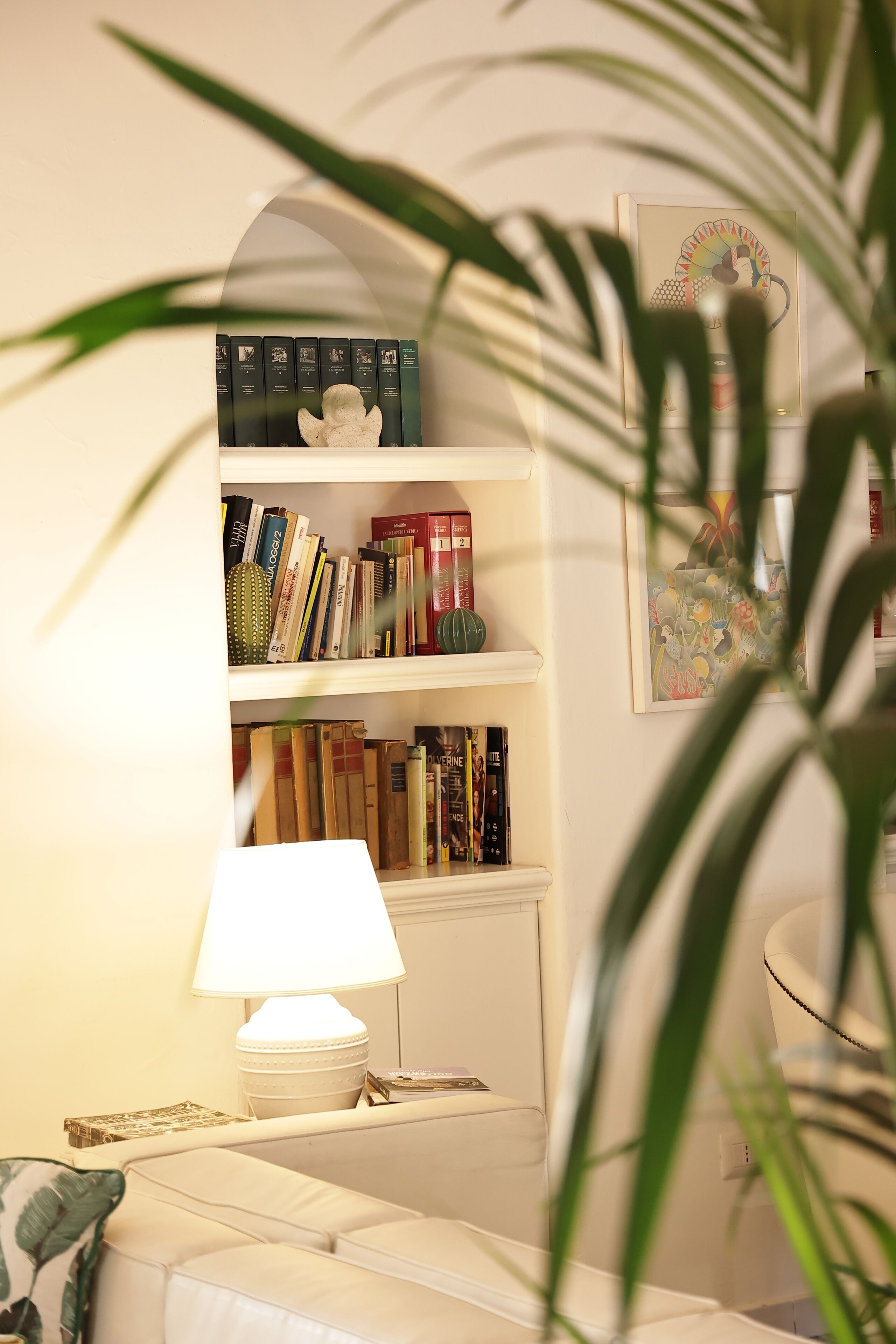 Un salon chaleureux avec une bibliothèque, une lampe et un canapé.