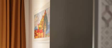 Una habitación de hotel con cama, un cuadro en la pared y un diseño decorativo en la pared.
