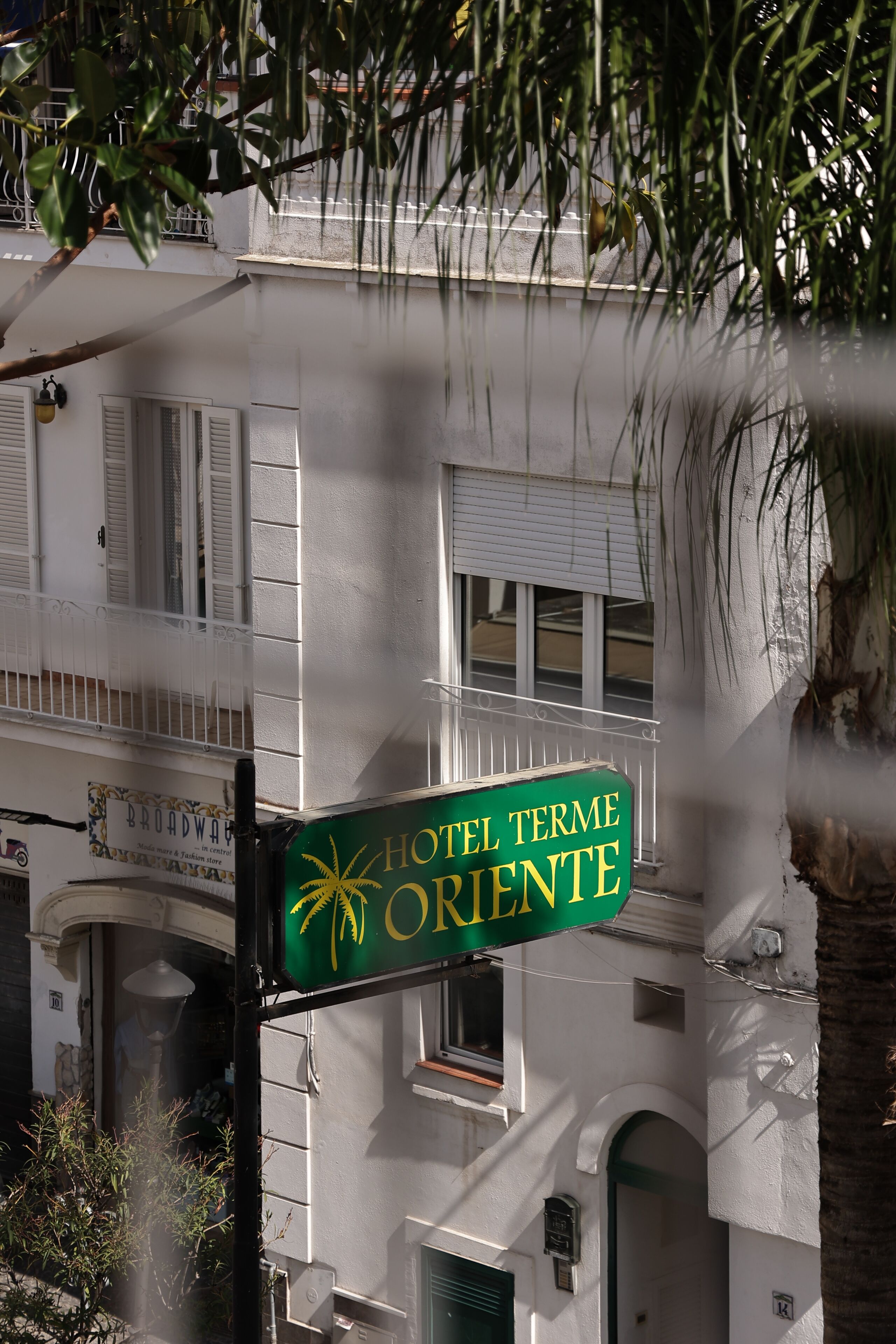 Letrero de hotel con diseño de palmera y sol, que indica un ambiente tropical.