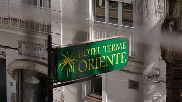 Letrero de hotel con diseño de palmera y sol, que indica un ambiente tropical.