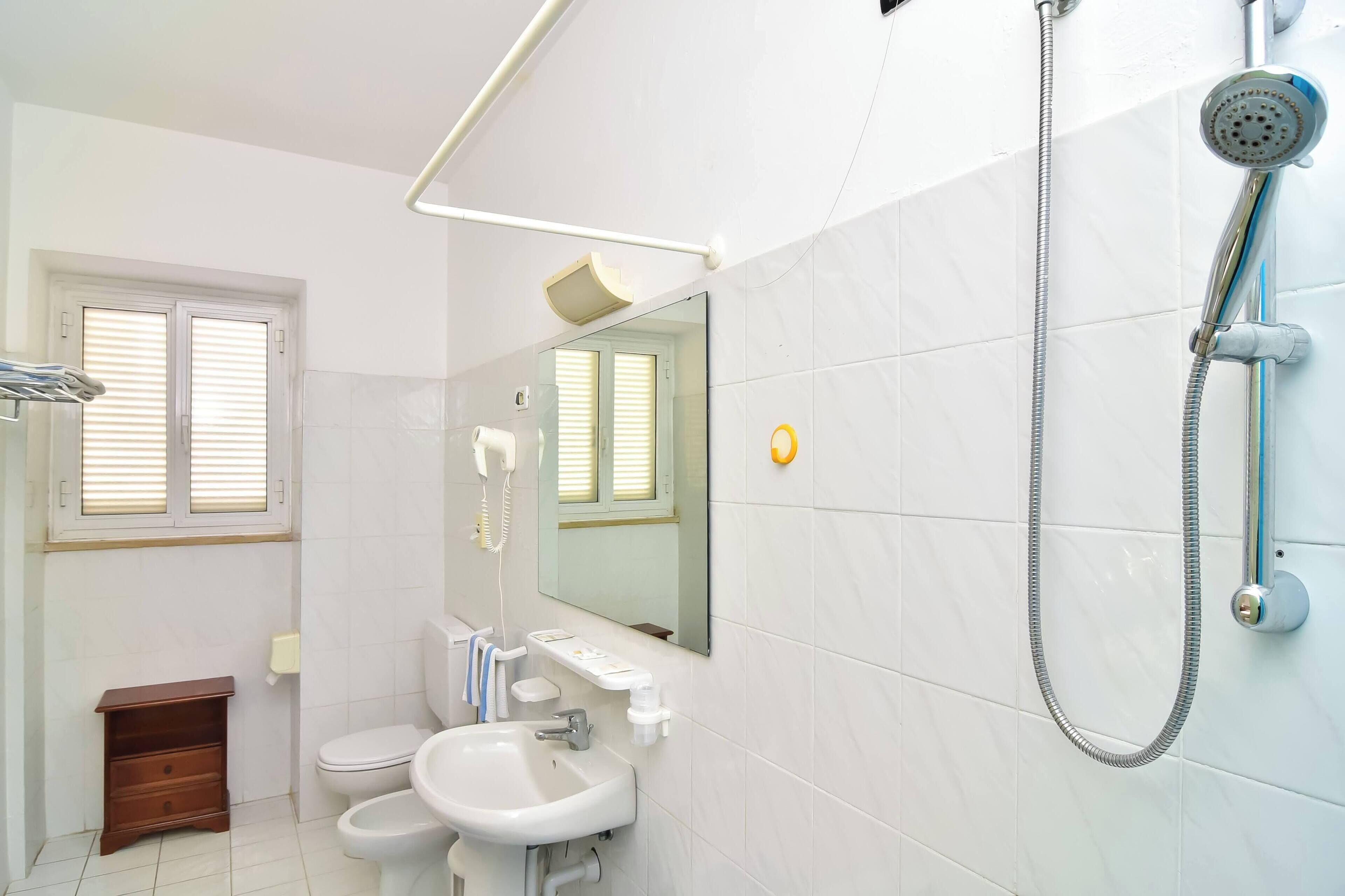 Un bagno moderno con servizi igienici, lavandino e doccia.