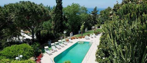 Piscine extérieure, parasols de plage, chaises longues