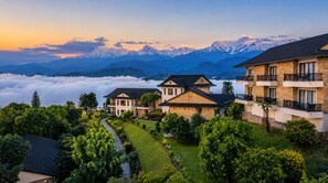 A residential area with houses, a pathway, and a mountainous backdrop. - Rupakot Resort (Lekhnath)