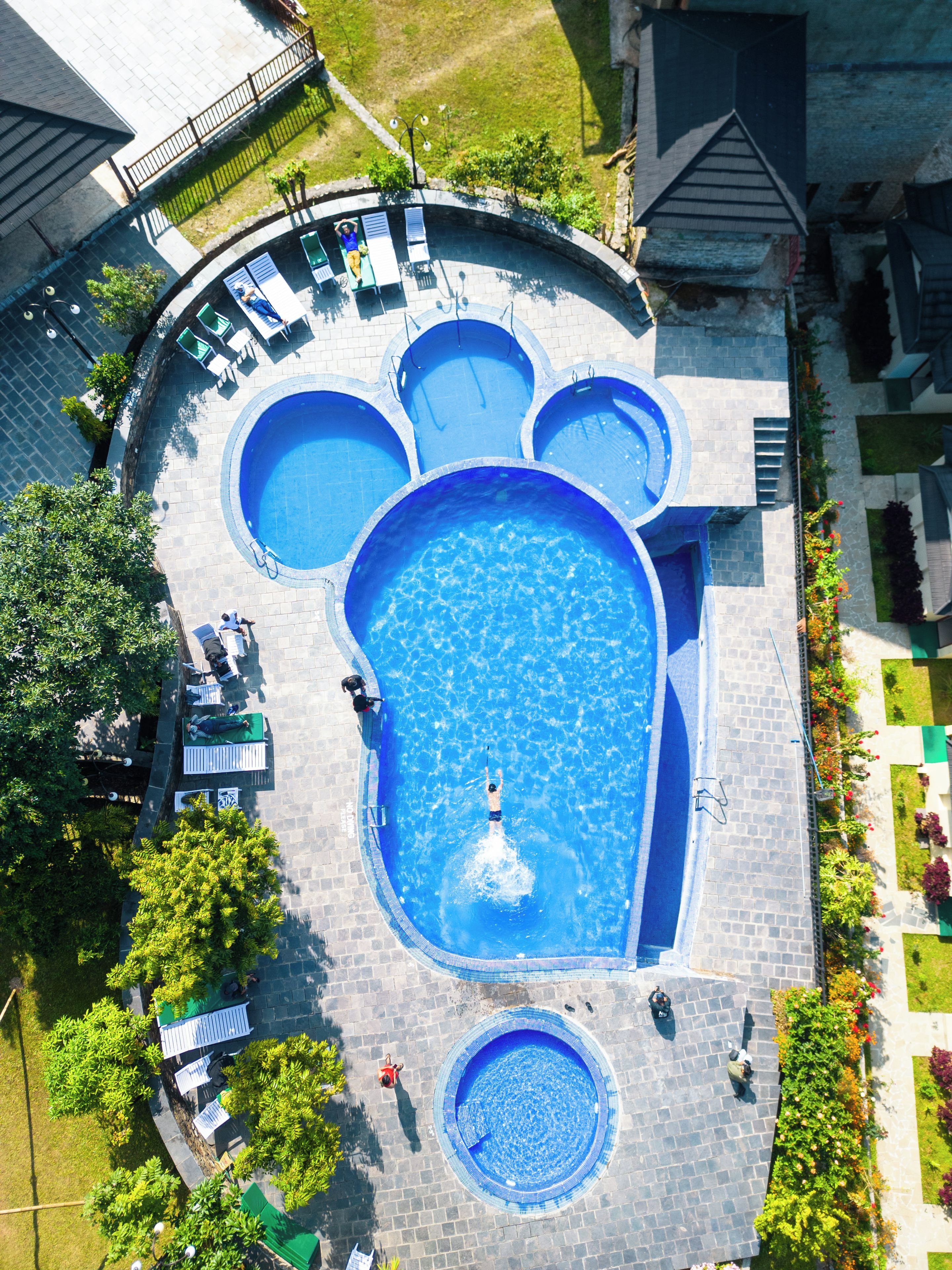 Una piscina en la azotea con varias secciones circulares y una fuente central.